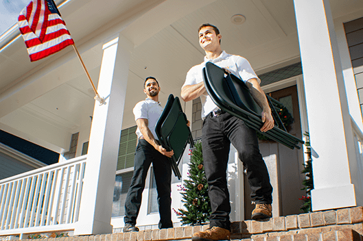 junkco employees carrying chairs off the porch